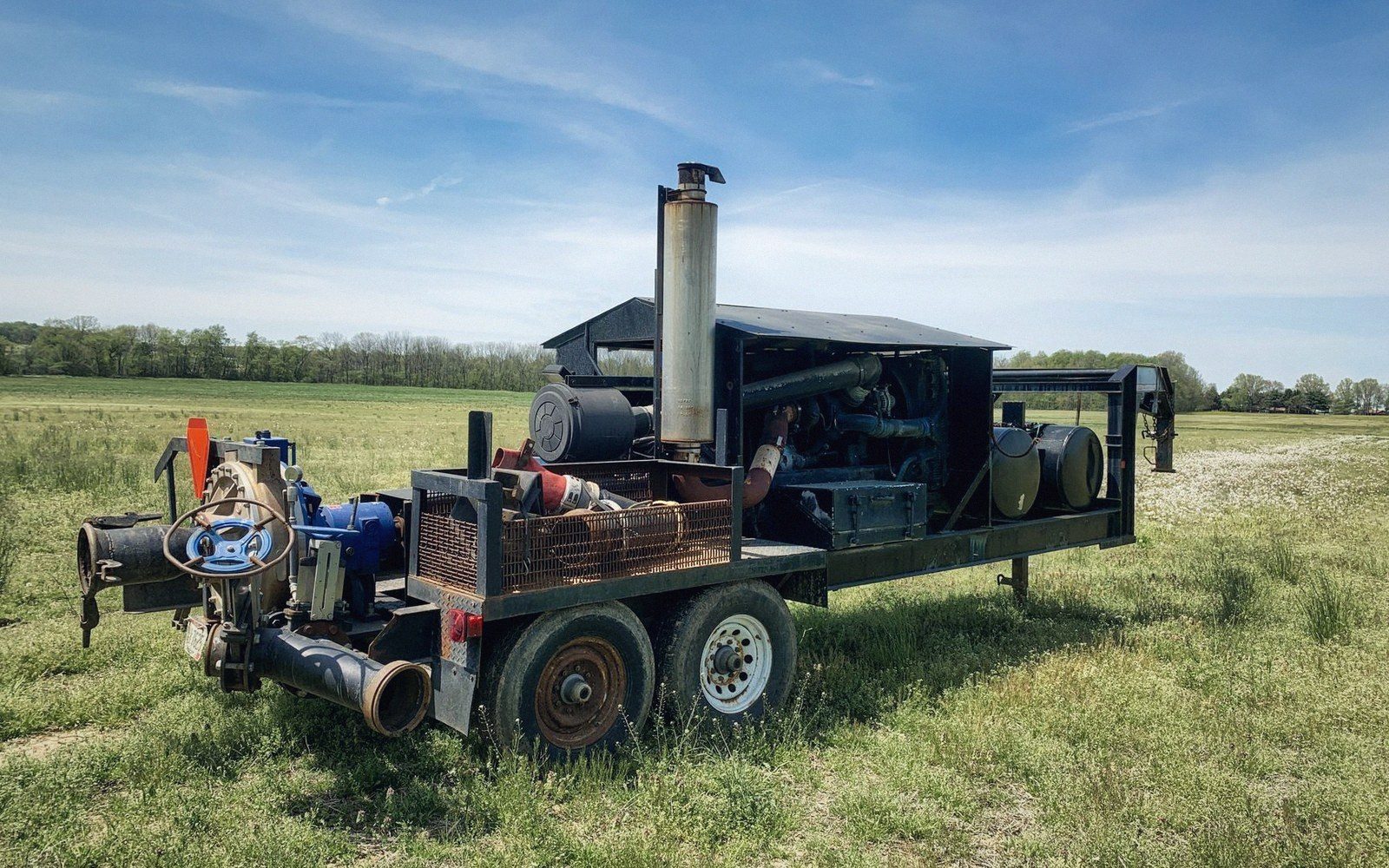 Trailer-mounted diesel irrigation pump with exhaust stack parked in a grassy field